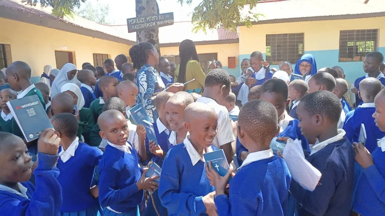 Schoolchildren in Musoma Town, Tanzania holding GO Movement Gospel of John booklets