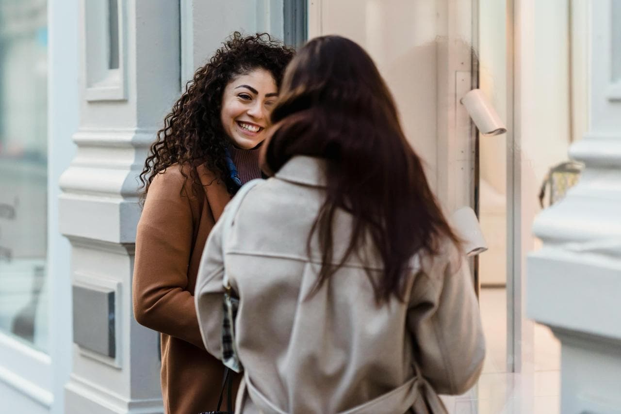Two friends talking on a city street