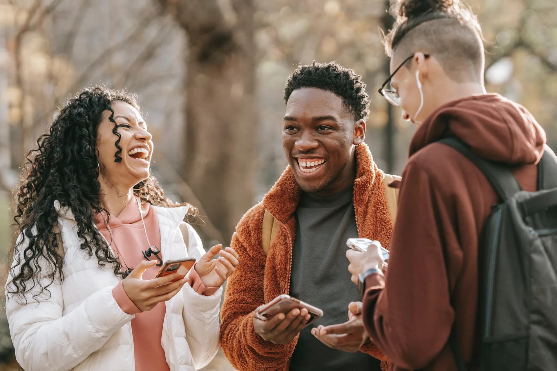 A young man laughing with friends outdoors